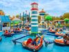 World of PAW Patrol Is Almost Here at Chessington! Bumper boats ride in a colorful theme park, with riders in orange and blue boats circling a central striped tower.