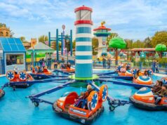 World of PAW Patrol Is Almost Here at Chessington! Bumper boats ride in a colorful theme park, with riders in orange and blue boats circling a central striped tower.
