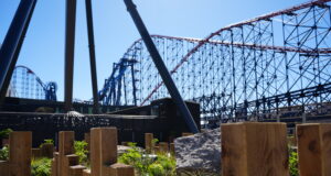 Blackpool Pleasure Beach Invites Guests to Ride AVIKTAS Early in Technical Rehearsal Event Blue-sky amusement park scene with a large blue roller coaster and red track behind wooden posts in the foreground