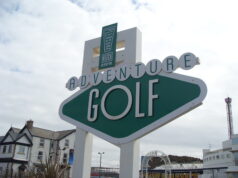 Save 50% on Adventure Golf at Blackpool Pleasure Beach Large green-and-white sign reading 'Adventure Golf' at a seaside resort, with a 'Pleasure Beach' emblem above.