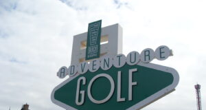 Save 50% on Adventure Golf at Blackpool Pleasure Beach Large green-and-white sign reading 'Adventure Golf' at a seaside resort, with a 'Pleasure Beach' emblem above.