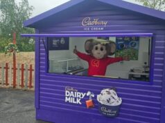 Gulliver’s Theme Parks Launch New Froneri Ice Cream Partnership Across UK Resorts Purple Cadbury Dairy Milk ice cream kiosk with mascot waving behind the window; outdoor seating nearby with purple chairs and umbrella.