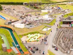 Dinosaur Park Near Tenby Listed for £4 Million Aerial view of a large outdoor amusement park with water slides, play structures, and families walking along paved paths.