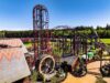 Drakon at Paultons Park: Ride Guide, Height Restrictions & Accessibility Red steel roller coaster with tall looping track in a sunny outdoor amusement park, with trees and blue sky in the background.