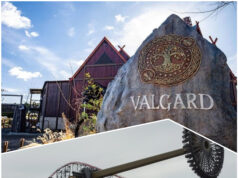 Why Valgard and Aviktas Make May 2026 a Must-Visit Month for Theme Parks Viking-themed amusement park entrance with a large carved rock and wooden buildings behind a roller coaster framework.