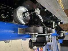 Behind-the-Scenes Photos Reveal Raven’s Transformation at Paultons Park Close-up of a roller and pulley assembly on a blue-painted industrial machine in a workshop environment