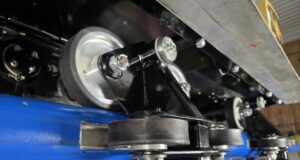 Behind-the-Scenes Photos Reveal Raven’s Transformation at Paultons Park Close-up of a roller and pulley assembly on a blue-painted industrial machine in a workshop environment