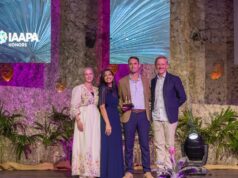Warner Bros World Yas Island Wins 2026 Applause Award for Creativity & Innovation Four people on a stage posing with an IAAPA Honors trophy for a photo event.