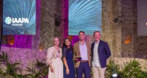 Warner Bros World Yas Island Wins 2026 Applause Award for Creativity & Innovation Four people on a stage posing with an IAAPA Honors trophy for a photo event.