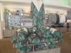 From Hoodies to Collectables: Pictures of Aviktas Merchandise Tall display of green and brown snake-print robes wrapped around a mannequin in a clothing store, with shelves of accessories in the background.