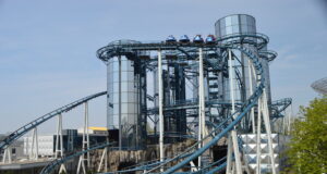 Euro-Mir to Remain Open Through 2026/27 as Europa-Park Confirms Future Farewell Blue roller coaster with riders on a high trestle, twisting around steel supports at an outdoor amusement park.