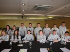 Blackpool Pleasure Beach Launches Applications for Its Junior Board of Directors 2026/27 Group of teens in grey hoodies posing around a banquet table in a restaurant or event space, smiling at the camera with glasses and papers on the table.
