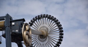 Every UK Theme Park Taking Part in the Great British Summer Savings Scheme Circular amusement ride wheel with numerous black passenger cabins around its rim, attached to a steel arm against a blue sky backdrop.