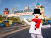 LEGOLAND Windsor Christmas 2026: Everything You Need to Know About This Magical Family Event Legoland Windsor Resort entrance with colorful towers and a snowman mascot in a black top hat and red scarf in the foreground.