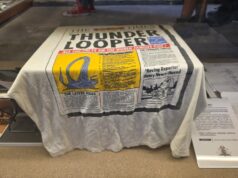 Archives Unlocked at Alton Towers: Step Behind the Scenes of Theme Park History White towel with a vintage newspaper print design spread over a surface, featuring bold black text and a yellow illustration panel.