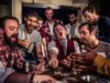 Scarily Good Savings at The York Dungeon Group of men around a cluttered table in a tavern, cheering while playing cards and sharing drinks.