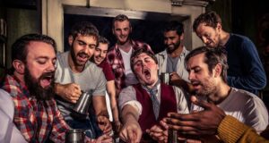 Scarily Good Savings at The York Dungeon Group of men around a cluttered table in a tavern, cheering while playing cards and sharing drinks.