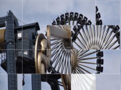 Play Theme Park Shuffle Puzzle Close-up of a large amusement ride wheel with passenger cars around the rim against a blue sky craft a Ferris wheel image