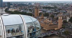 London Eye Adds Free Time Out Audio Experience to Every Ticket This Summer People inside a glass pod of the London Eye taking selfies with London's skyline and the River Thames below on a cloudy day.