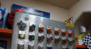 Would You Buy a Piece of Alton Towers History? The Nemesis Panel Auction Is Something Special Metal control panel with labeled switches and green/orange indicator lights in a workshop setting, including Auto/Manual modes and Lift/Brake labels.